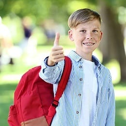 Young boy with braces giving thumbs up