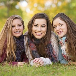 Three young women smiling together outdoors