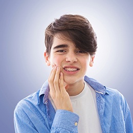 A teen rubbing his cheek due to an orthodontic emergency
