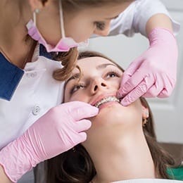 Orthodontist examining patient's braces