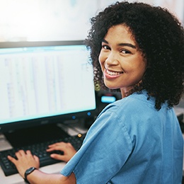 a front desk staff member in a dental office smiling