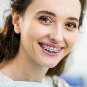 A young girl wearing metal braces in Huntington and smiling