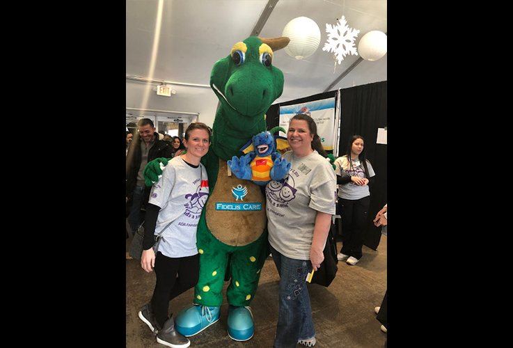 Two team members and mascot at oral health event