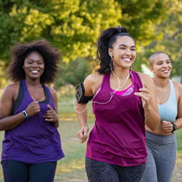 Group of woman smiling while jogging together