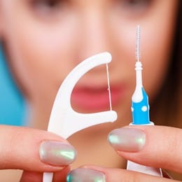 Up-close photo of a flosser and interdental brush 