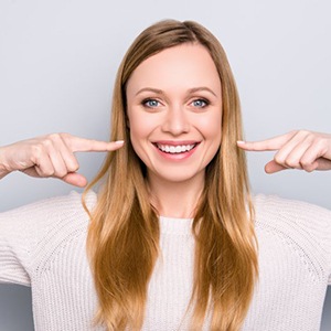 a woman pointing at her straight smile