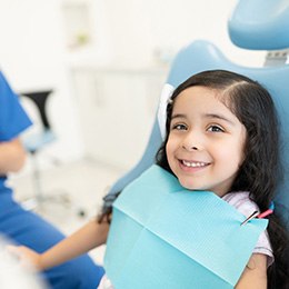 Smiling young girl in dental treatment chair