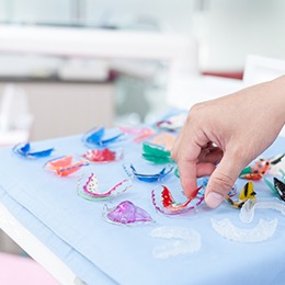 A dentist selecting from one of many retainers