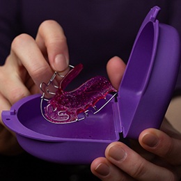A patient putting their removable retainer in a case