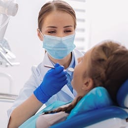 An orthodontist in Huntington examining a patient’s smile to determine if braces are right for their needs