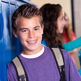 Teen boy with bracess in school hallway