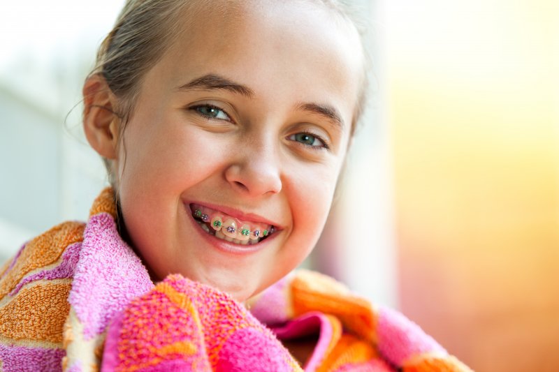 Girl in pink and orange smiling with braces