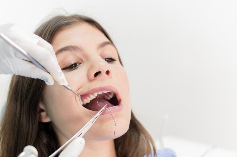 teenage girl brunette having braces placed by orthodontist