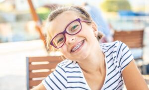 Young girl smiling wearing braces.